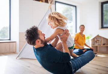 A young family with small child indoors in bedroom having fun. - HPIF17755