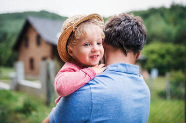 Eine Nahaufnahme eines nicht erkennbaren Vaters mit einem kleinen Jungen, der im Sommer im Garten steht. - HPIF17808