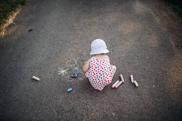 Eine Rückansicht von niedlichen Kleinkind Mädchen im Freien in der Landschaft, Kreidezeichnung auf der Straße. kopieren Raum. - HPIF17857
