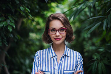 A young woman standing in botanical garden. Copy space. - HPIF17932