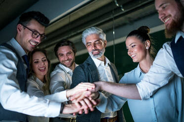 A group of business people with computer in an office in the evening, expressing excitement. - HPIF18128