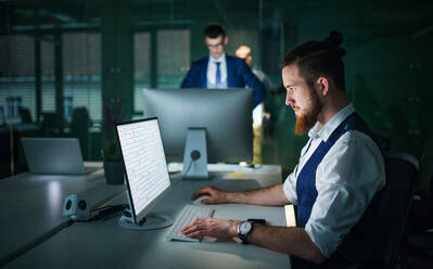 Zwei junge Geschäftsleute mit Desktop-Computer in einem Büro, arbeiten. - HPIF18300