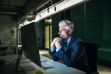 Ein Porträt von reifen Geschäftsmann mit Computer in einem Büro, arbeiten. - HPIF18311