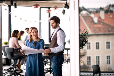 Eine Gruppe junger Geschäftsleute in einem Büro, die Probleme bei der Arbeit besprechen. - HPIF18427