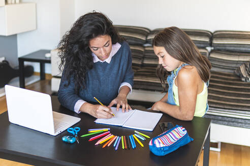 Freiberufler Mutter führt Tochter Zeichnung in Notebook mit Laptop auf dem Tisch - JAQF01224