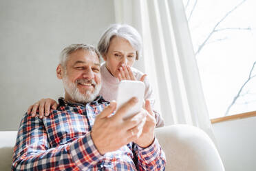 Reifes Paar Videoanrufe über Smartphone zu Hause - MDOF01154