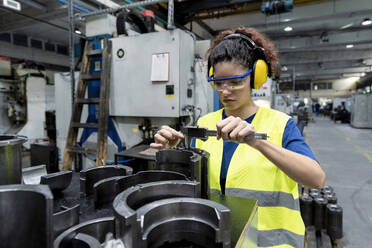 Maintenance engineer in protective workwear doing quality control in modern factory - AAZF00595