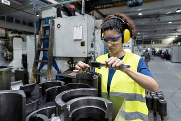 Wartungsingenieur für Arbeitsschutzkleidung bei der Qualitätskontrolle in einer modernen Fabrik - AAZF00595