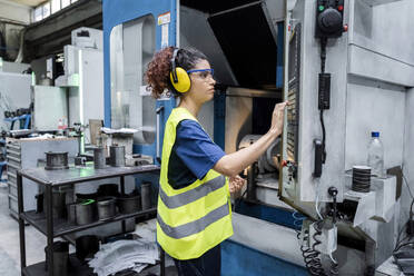 Wartungsingenieur, der eine CNC-Maschine in einer modernen Fabrik bedient - AAZF00604