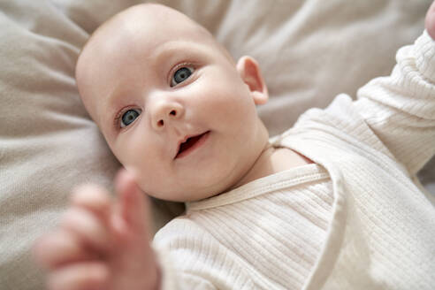 Cute baby girl lying down in crib at home - ABIF01990