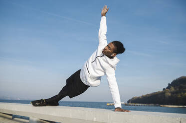 Athlete balancing on railing at sunny day - ALKF00308