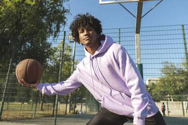 Sportler dribbelt Basketball auf dem Sportplatz - ALKF00315