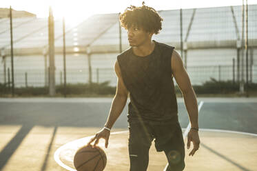 Contemplative athlete playing basketball at sports court - ALKF00324