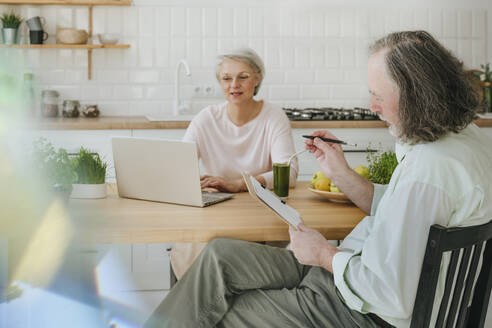 Mann diskutiert mit Ernährungsberaterin, die zu Hause am Laptop arbeitet - YTF00869