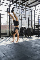 Man practicing handstand at rooftop gym - IKF00679