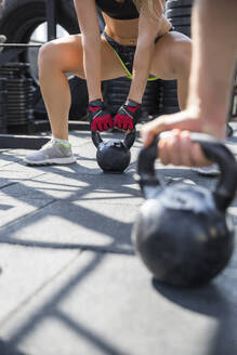 Freunde üben mit Kettlebells im Fitnessstudio auf dem Dach - IKF00692