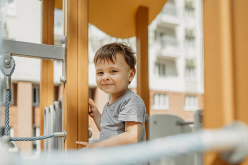 Lächelnder Junge hat Spaß auf dem Spielplatz - ANAF01458