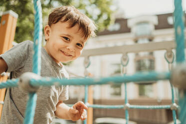 Happy boy enjoying in playground at sunny day - ANAF01462