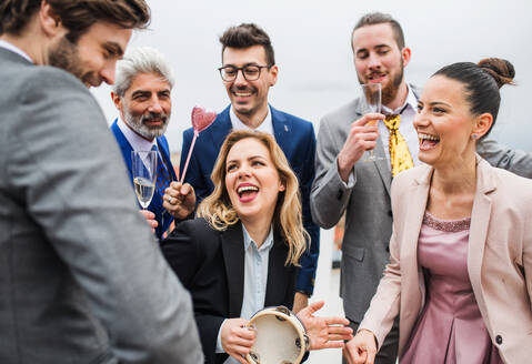 Eine große Gruppe fröhlicher Geschäftsleute feiert eine Party auf der Dachterrasse in der Stadt. - HPIF18540