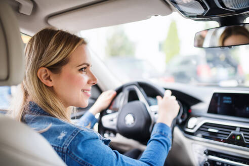 Junge Frau, die im Auto sitzt und fährt, Kopierraum. - HPIF18555