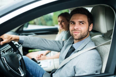 A young couple sitting in a car, driving. - HPIF18592