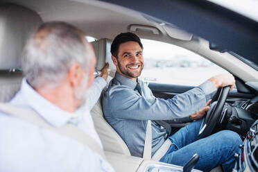 Senior father and son sitting in car, driving and talking. - HPIF18663