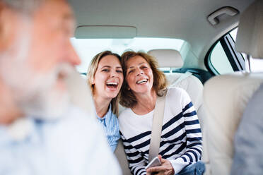 Fröhliche männliche und weibliche Erwachsene sitzen im Auto und machen einen Ausflug. - HPIF18665