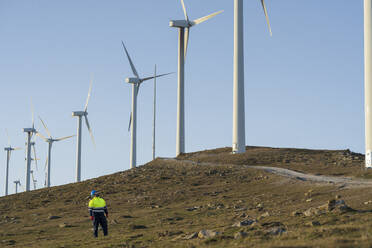 Ingenieur steht in der Nähe von Windkraftanlagen - SNF01679