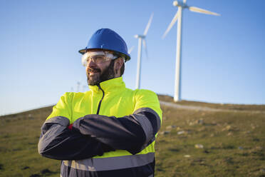 Lächelnder reifer technischer Ingenieur mit verschränkten Armen - SNF01680