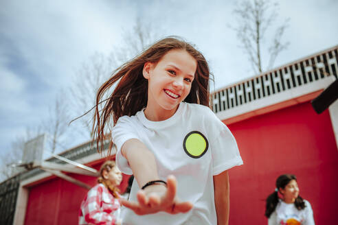 Lächelndes jugendliches Mädchen tanzt auf dem Spielplatz - MDOF01172