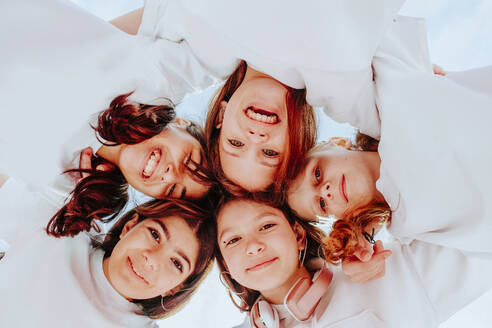 Smiling teenage friends huddling together - MDOF01199