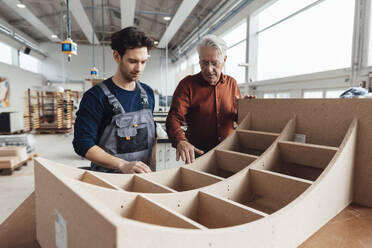 Senior businessman having discussion with carpenter in workshop - JOSEF19271