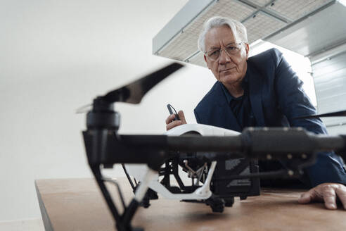 Leitender Geschäftsmann prüft Drohne in der Industrie - JOSEF19348