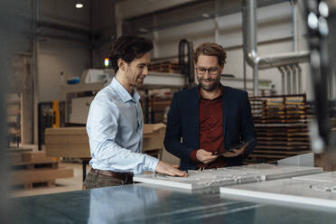 Reifer Geschäftsmann mit Kollege, der in der Industrie Holz anfasst - JOSEF19354