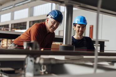 Businessman with colleague operating machinery in factory - JOSEF19397