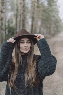 Junge Frau mit langen Haaren und Hut auf einem Feld - VBUF00316