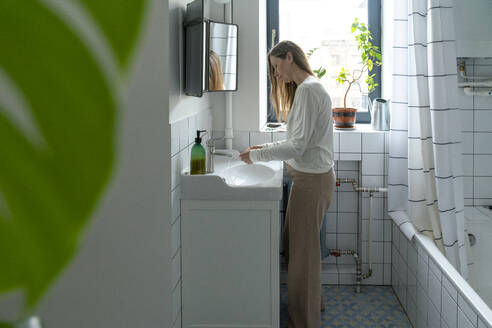 Frau beim Händewaschen im Badezimmer zu Hause - VPIF08119