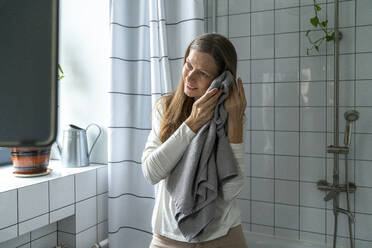 Glückliche reife Frau reinigt Gesicht mit Handtuch - VPIF08120