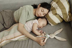 Mutter und Tochter schlafen zusammen auf dem Sofa zu Hause - KPEF00031