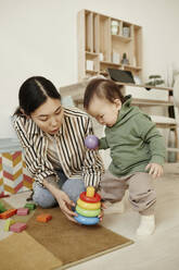 Mother and daughter playing with toys at home - KPEF00042