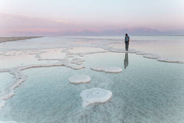 Junge Frau steht auf Salzformationen im Toten Meer bei Sonnenuntergang - PCLF00624