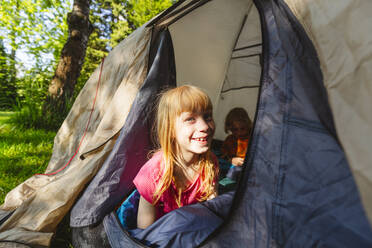 Happy strawberry blond girl enjoying camping - IHF01371