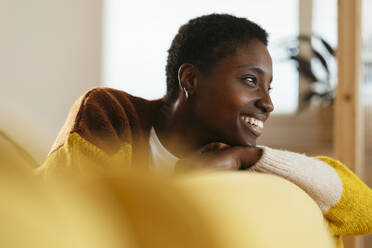 Thoughtful woman sitting in living room at home - EBSF03456