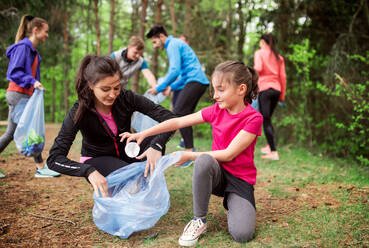 Eine Gruppe aktiver junger Menschen, die in der Natur Müll aufsammeln, ein Plogging-Konzept. - HPIF18760