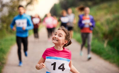 A large group of active multi generation people running a race competition in nature. - HPIF18768