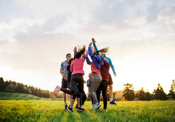 Eine große Gruppe fitter und aktiver Menschen, die nach dem Sport in der Natur springen. - HPIF18849