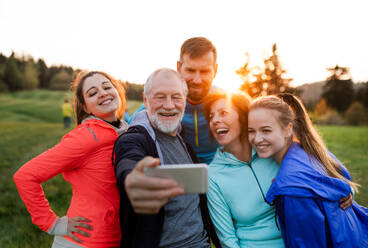 Eine Gruppe energiegeladener Menschen macht ein Selfie nach einem erfrischenden Workout in der freien Natur - HPIF18873