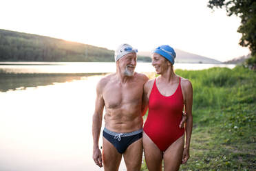 Älteres Paar im Badeanzug, das vor dem Schwimmen am See steht, Kopierraum. - HPIF18962