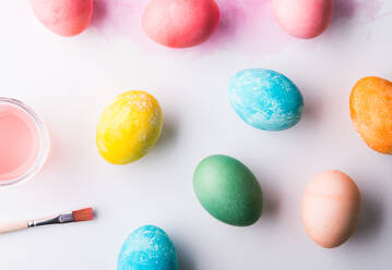 Bemalte Eier, Farbe und Pinsel flach auf einem weißen Hintergrund legen. Ostern und Frühling Zusammensetzung. Studio Schuss. Kopieren Raum. - HPIF19090