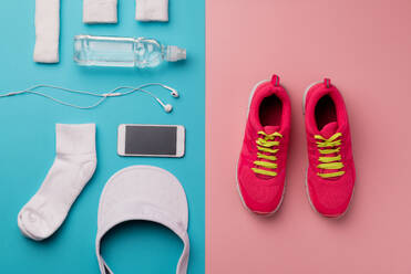 A studio shot of running shoes, smartphone and other sport equipment on pink background. Flat lay. - HPIF19124